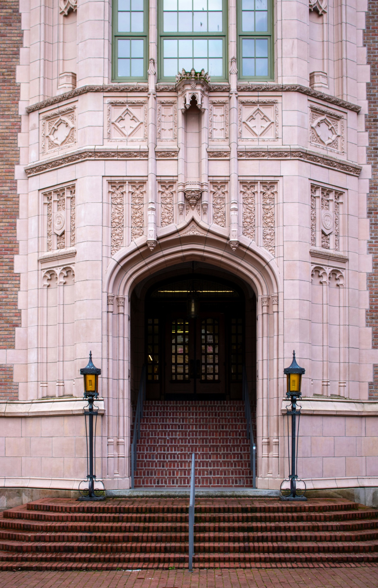 An ornate school entrance framed by stonework and brick steps.